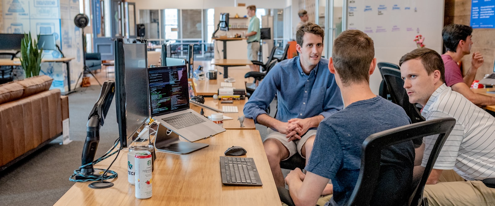 Colleagues discussing what is on screen in an open office